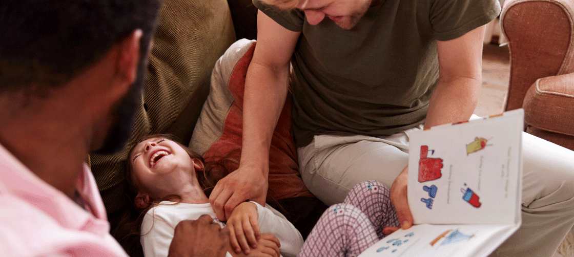 parents tickling their daughter