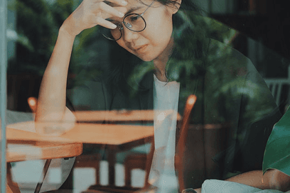 distressed woman looking out a window